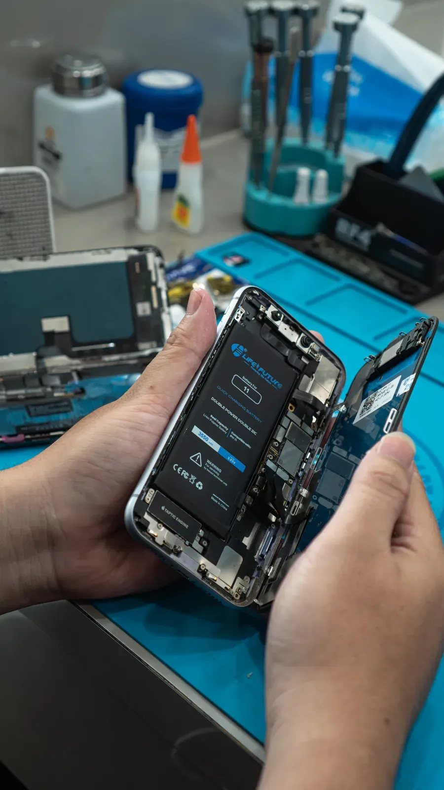 A Raja Repair technician disassembling and repairing a smartphone