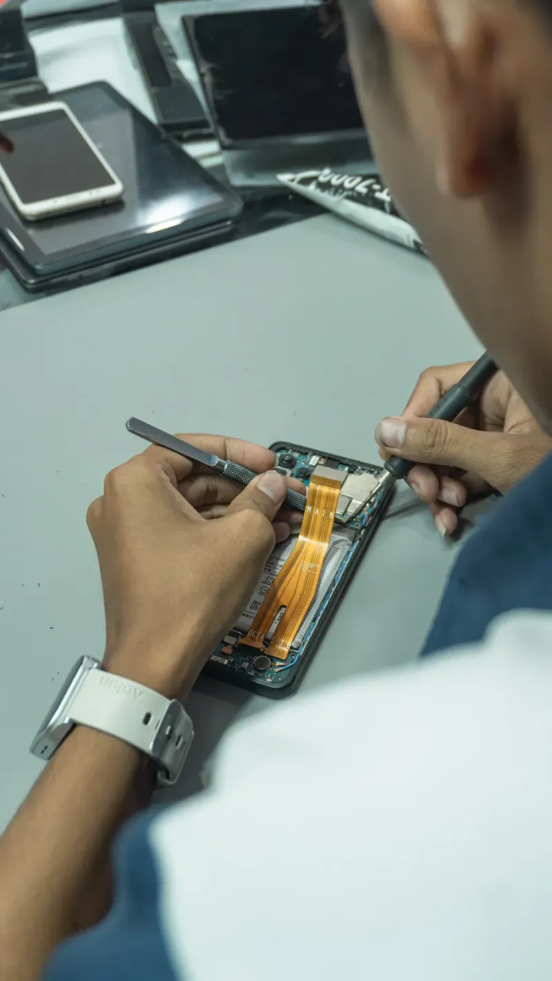 Teknisi memperbaiki smartphone di meja kerja