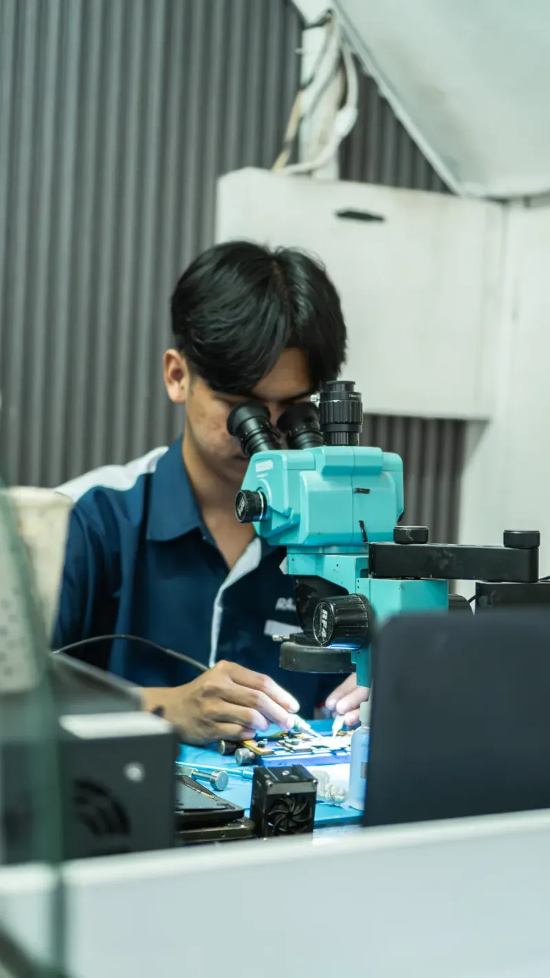 Teknisi memperbaiki smartphone di meja kerja